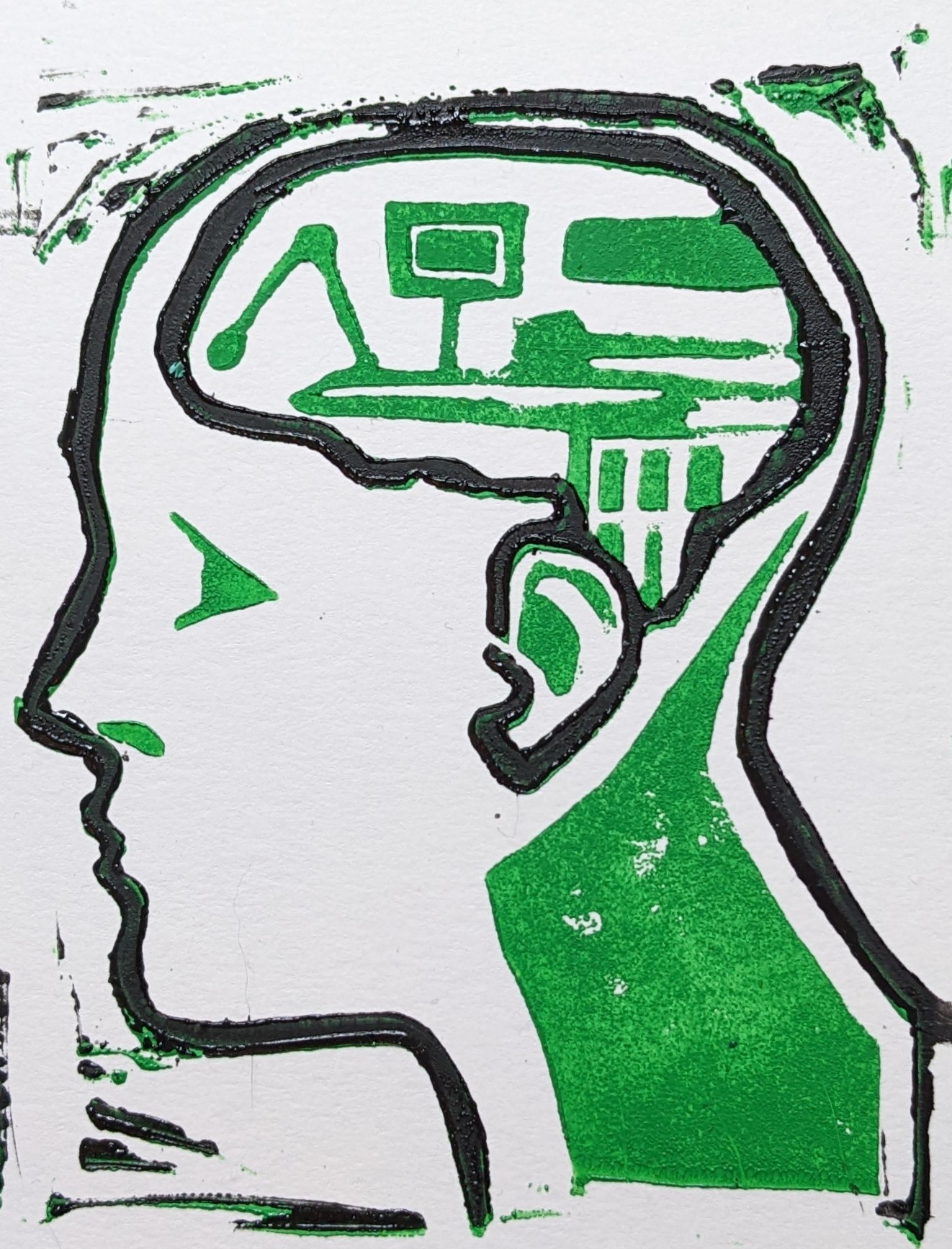 Green and black lino print on white paper of a side profile head. Inside the head is a brain seeminly made of computer parts. The inside of the head is green and the outline is black.